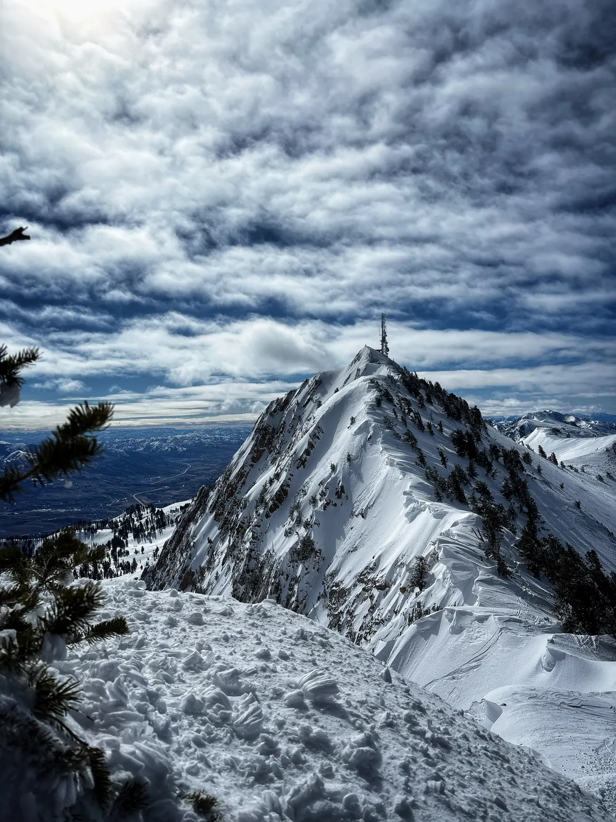 Snow-covered summit ridge under heavy clouds